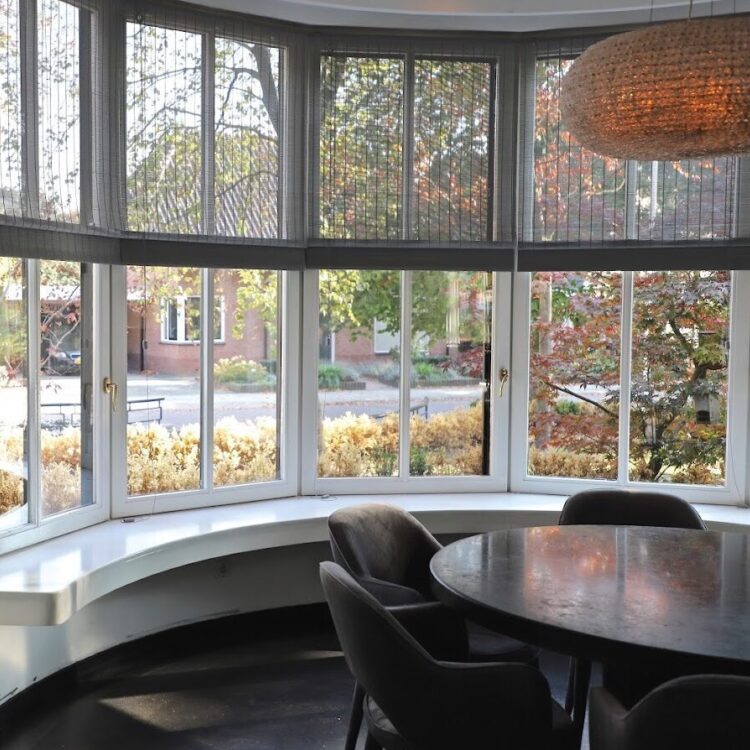 Zwart geweven hout rolgordijn in een erker