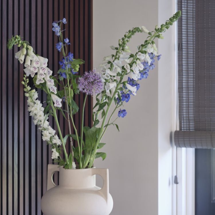 Sfeerbeeld van bruin geweven hout rolgordijnen en donkere wandpanelen