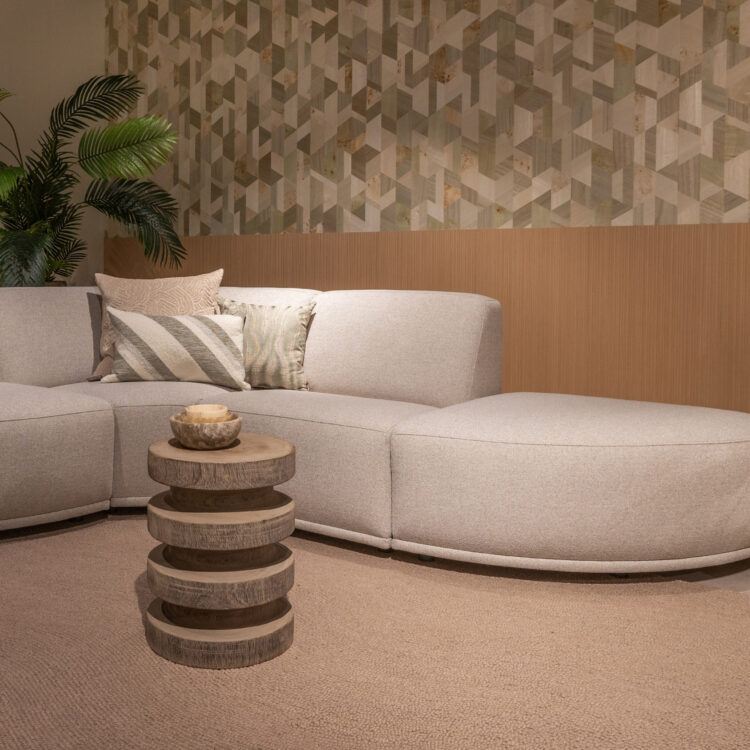 Woonkamer met Arte behang en lichten eiken wandpanelen en grijze hoekbank met beige vloerkleed