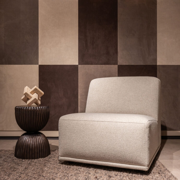 Woonkamer met leren wandbekleding van Belledo in bruin en beige tinten met grijze fauteuil.