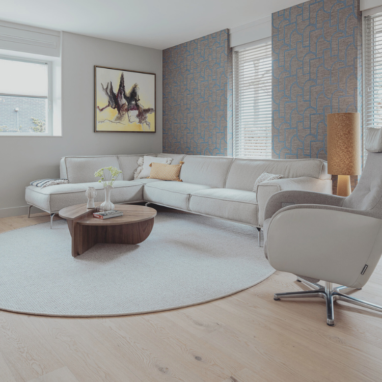 Zithoek na de make-over met warm Arte behang, rond vloerkleed, stijlvolle tv-kast en sfeervolle raambekleding