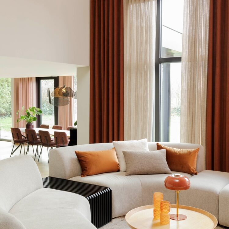 Bruine overgordijnen en beige inbetweens in de woonkamer