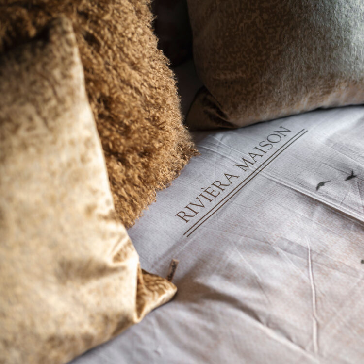 Detail beddengoed en verschillende sierkussens op bed