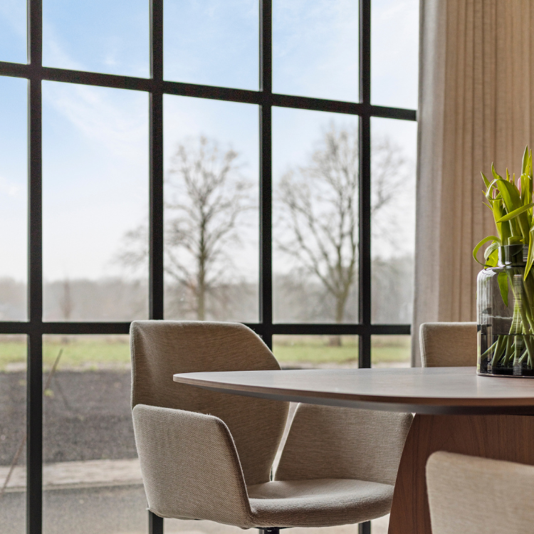 Eetkamer met grote raampartij en beige inbetweens