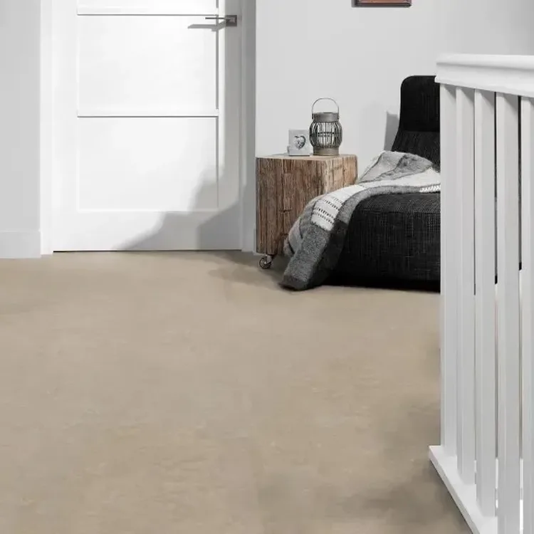 Overloop met beige marmoleumvloer, zwarte stoel met plaid, houten bijzettafel en witte trapleuning