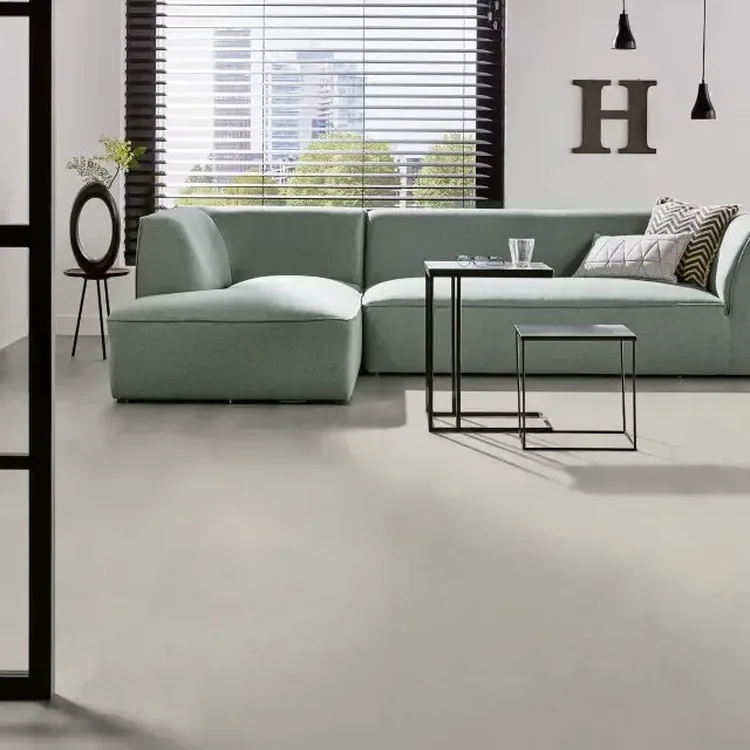 Moderne woonkamer met lichtgrijze marmoleumvloer, mintgroene hoekbank en zwarte bijzettafels