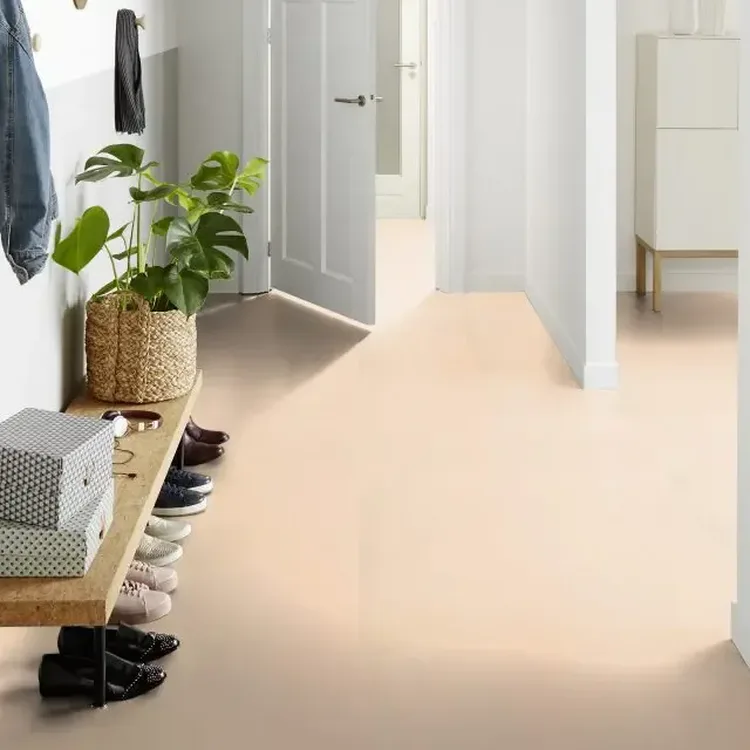 Lichte gang met zandkleurige marmoleumvloer, houten schoenenbank, plant in rieten mand en witte deuren