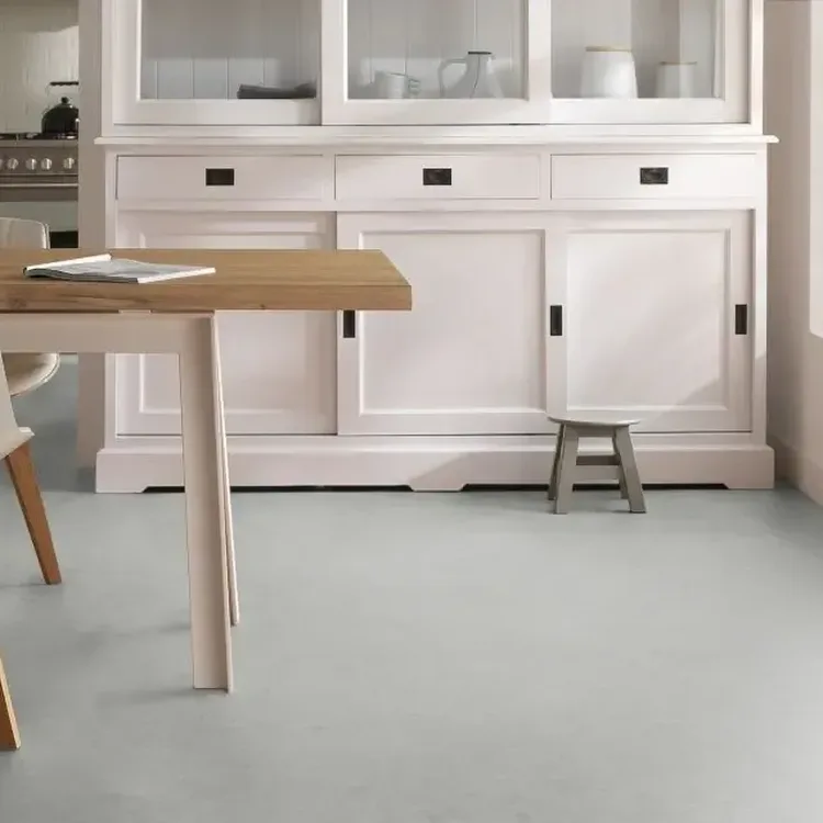 Keuken met lichtgrijze marmoleumvloer, witte buffetkast en houten eettafel