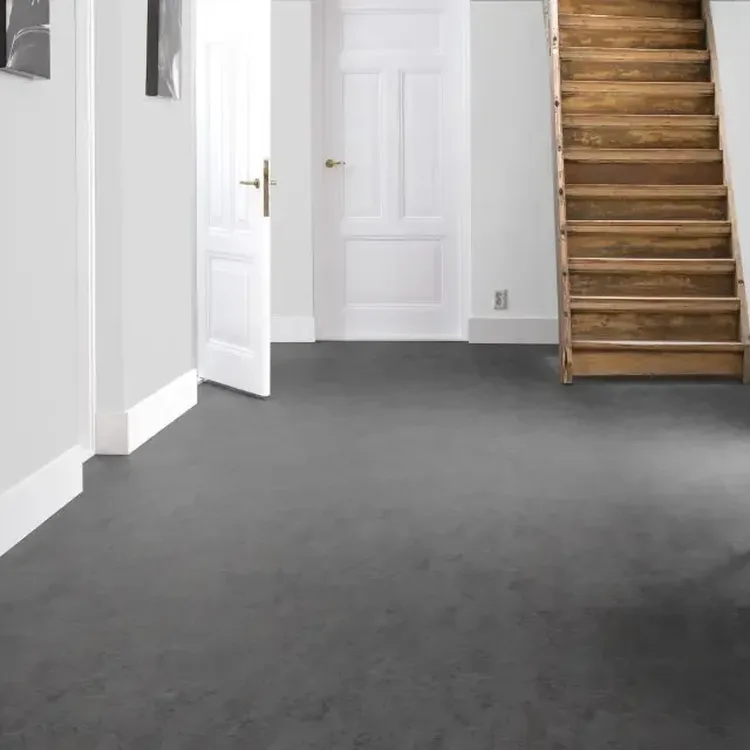 Lichte hal met grijze marmoleumvloer, witte deuren en een houten trap