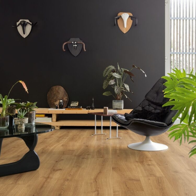 Woonkamer met donkere muurverf en warme eikenlook laminaat