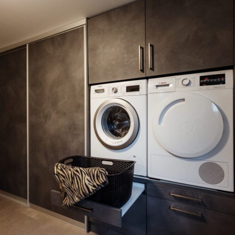 Donker grijze wasmachinekast op maat met lades voor wasmand